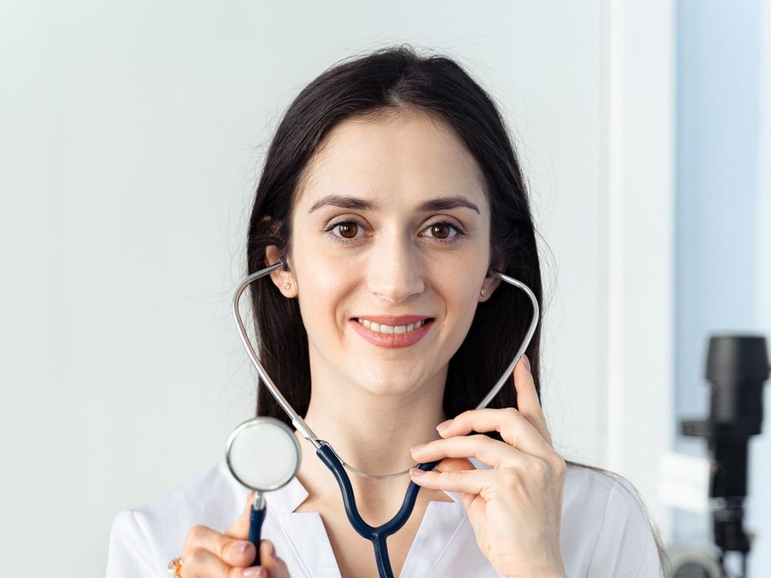 A smiling doctor in a hospital corridor